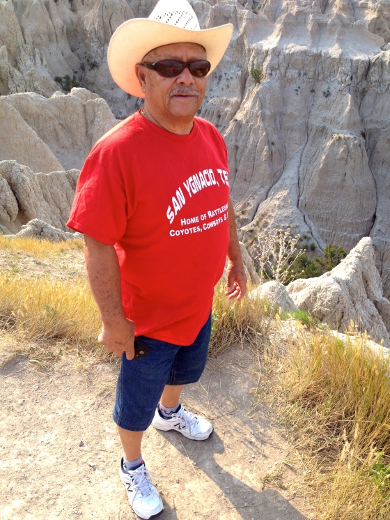My father stands on the edge of a badlands canyon.